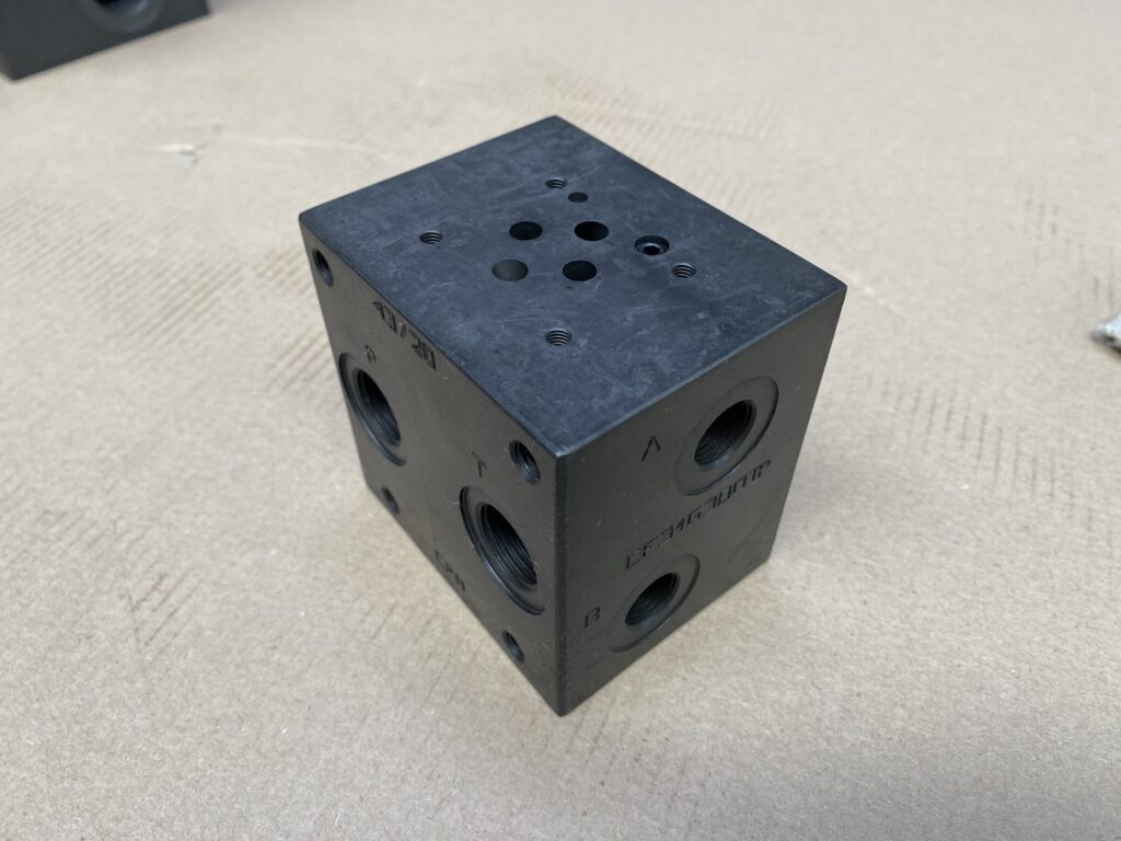 CETOP 03 hydraulic block, a compact hydraulic manifold for hydraulic valves, used in fluid control systems.