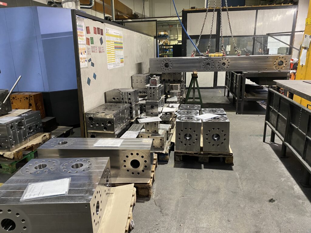 Series of hydraulic blocks carefully aligned in the warehouse, highlighting the variety and quality of the products offered by the hydraulic company.